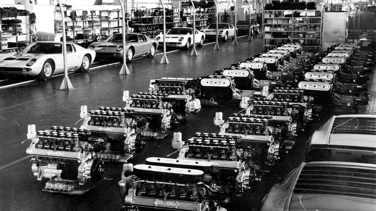 Historic Sant Agata Bolognese factory floor with V12 engines and Lamborghini Miura models from the 1960s